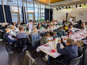 Menschen essen gemeinsam in großer Halle