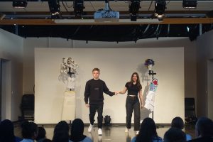 Zwei Personen auf Bühne vor Publikum